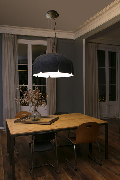 Dining room with a wooden table, chairs, and a large pendant light.
