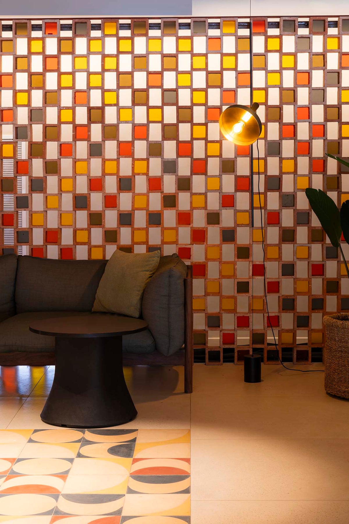 Modern living room with a colorful mosaic wall and patterned floor.