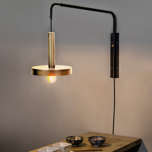 Modern wall-mounted lamp with a wooden shade on a wooden surface against a gray wall.