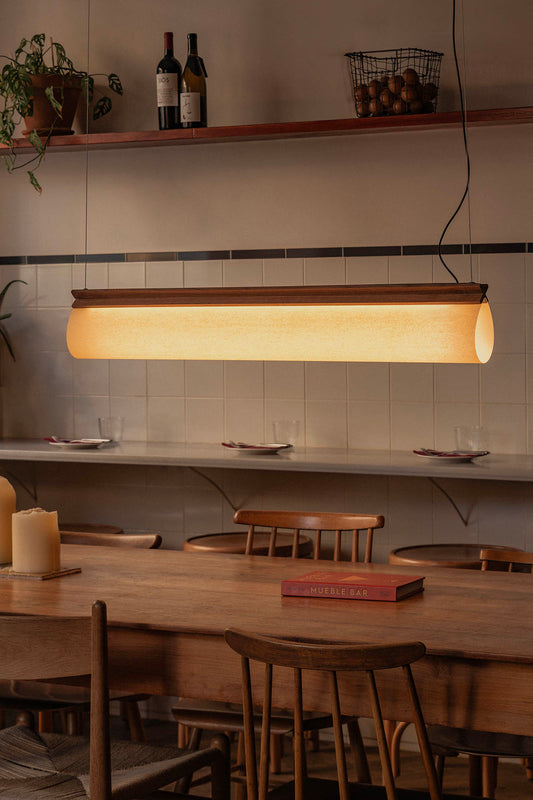 Dining area with wooden table, chairs, and pendant light fixture.