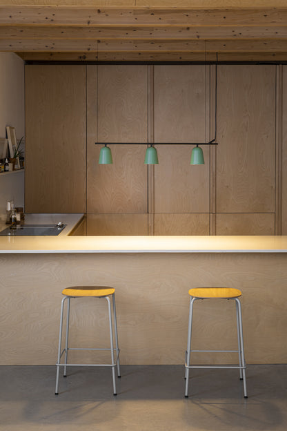Modern kitchen with wooden cabinets, a countertop, and two yellow stools.