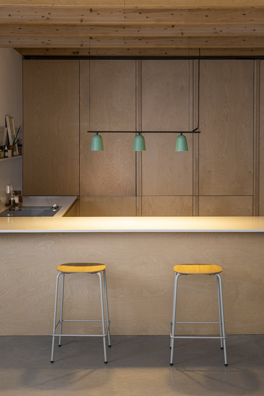 Modern kitchen with wooden cabinets, a countertop, and two yellow stools.