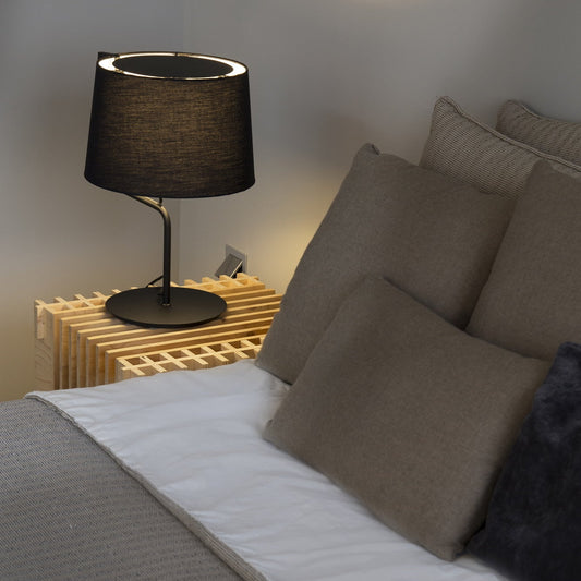 Bedroom scene with a bed, lamp, and radiator.