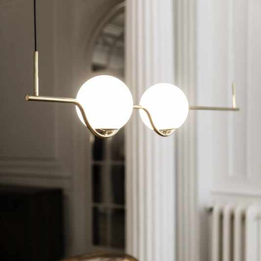 Modern pendant light hanging above a wooden table in an elegant room.