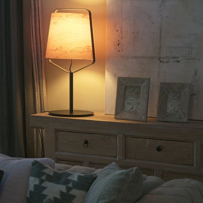 Napoleon III style sideboard with lamp and framed pictures in a cozy room.