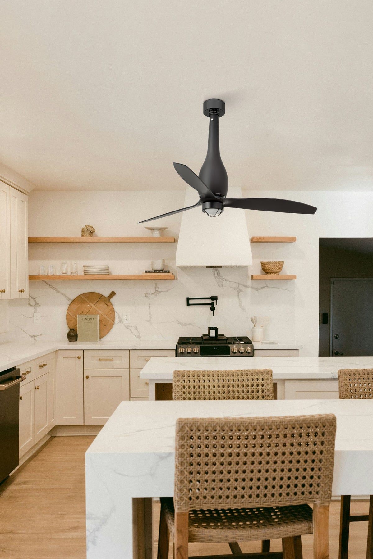 Modern kitchen with marble countertops, wooden shelves, and a ceiling fan.
