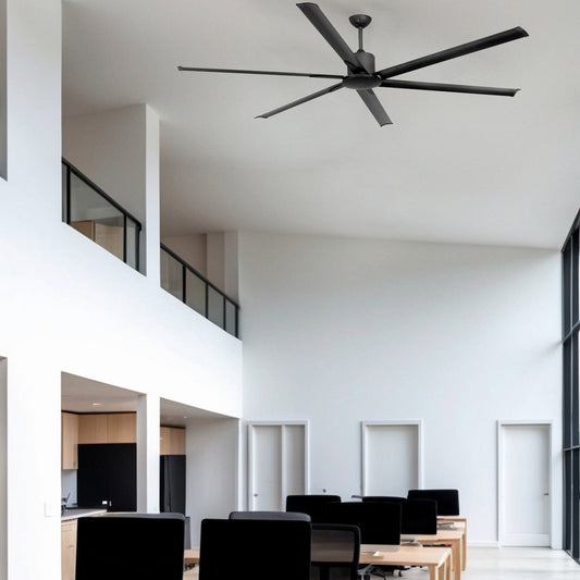 Modern office space with desks, computers, and a ceiling fan.