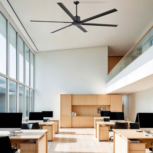 Modern office space with wooden desks, chairs, and a large ceiling fan.