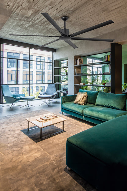 Modern living room with green sofa, coffee table, and ceiling fan