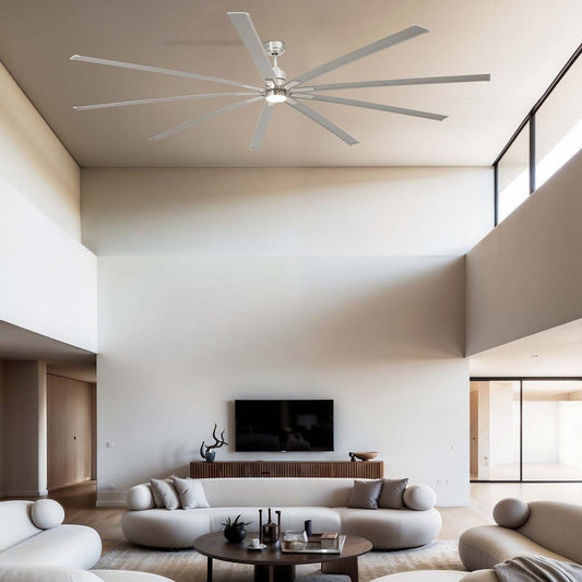 Modern living room with beige sofas, a coffee table, and a ceiling fan .