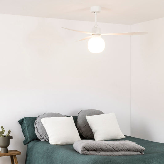 Bedroom with a bed covered in green bedding and white pillows, next to a wooden nightstand.
