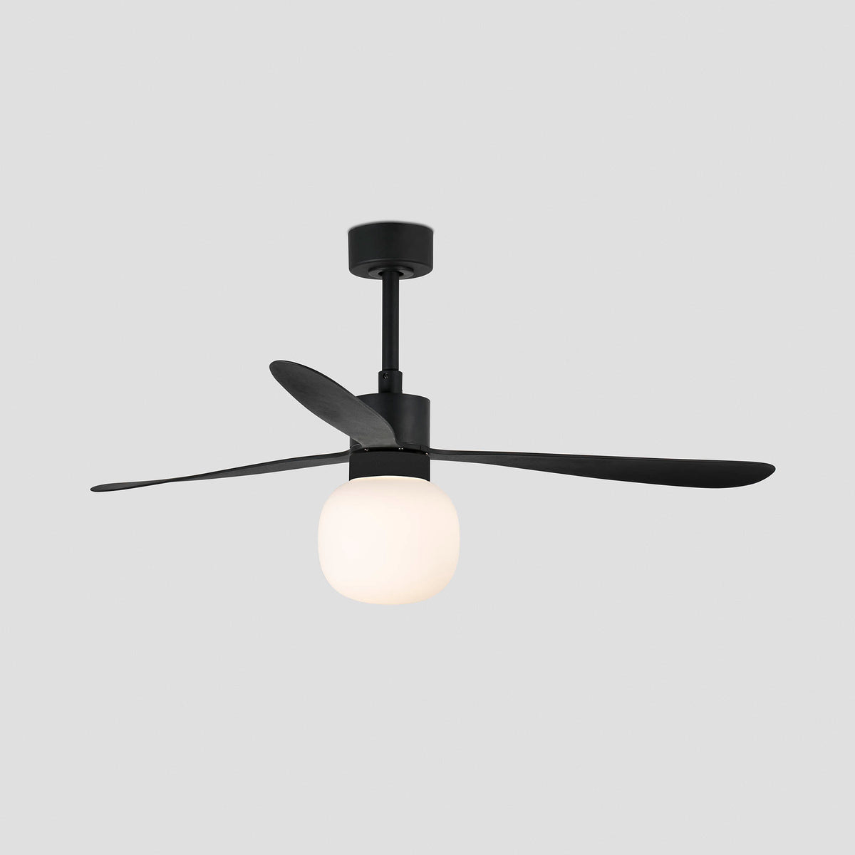 A modern matte black ceiling fan with three blades and a frosted white globe light, shown against a solid light gray background.