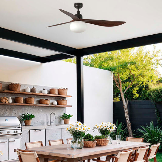 Outdoor dining area with a wooden table and chairs, plants, and a ceiling fan.