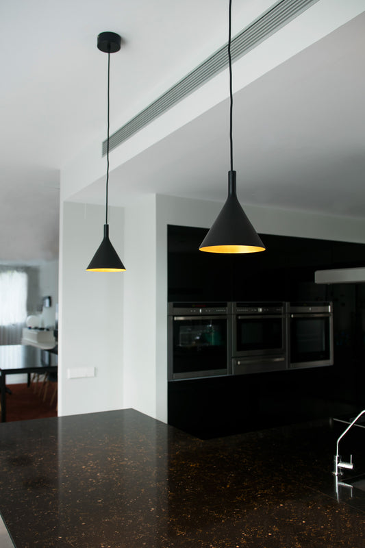 Modern kitchen with black pendant lights and a dark countertop.