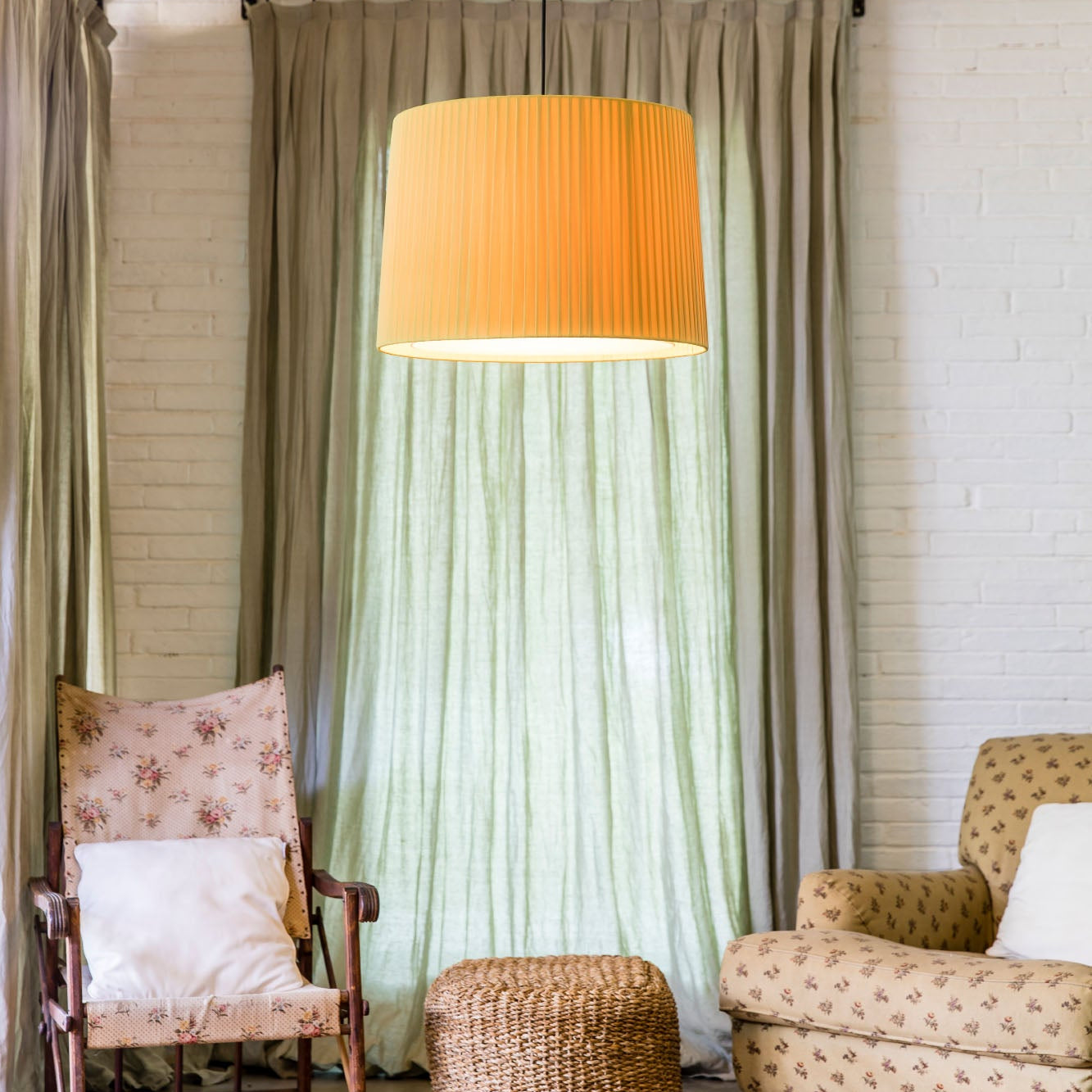 Living room with two armchairs, a ottoman, and a large lamp with an orange shade.