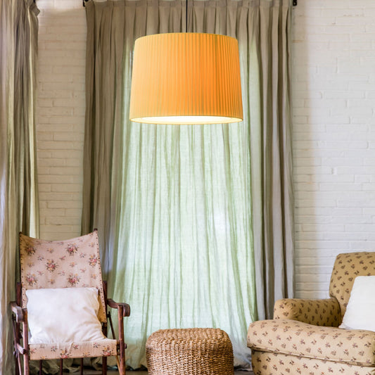 Living room with two armchairs, a ottoman, and a large lamp with an orange shade.