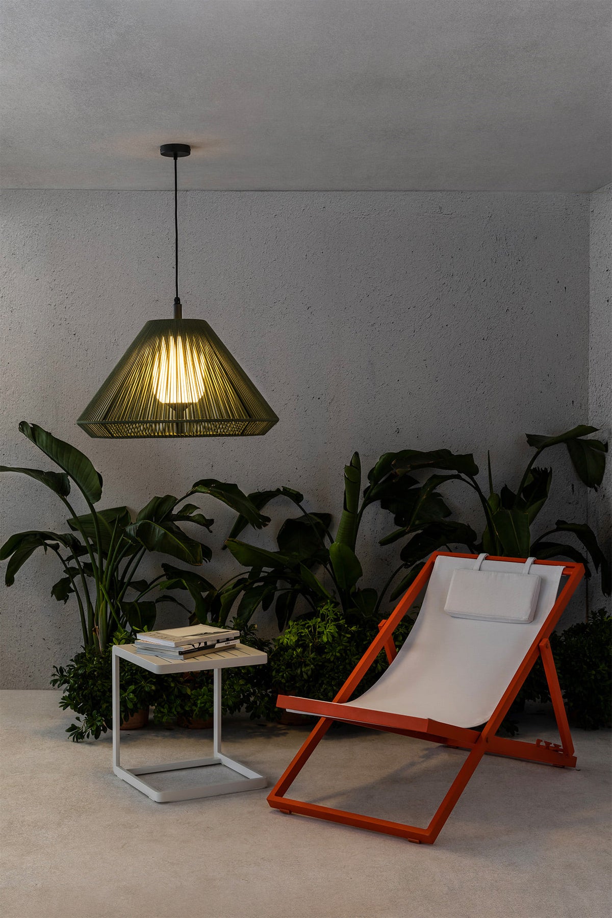 Modern lounge chair with a side table and plants in a minimalistic room and outdoor pendant lamps