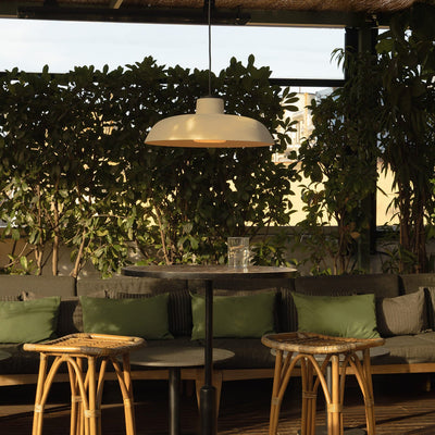 Outdoor patio area with tables, chairs, and a hanging light fixture.