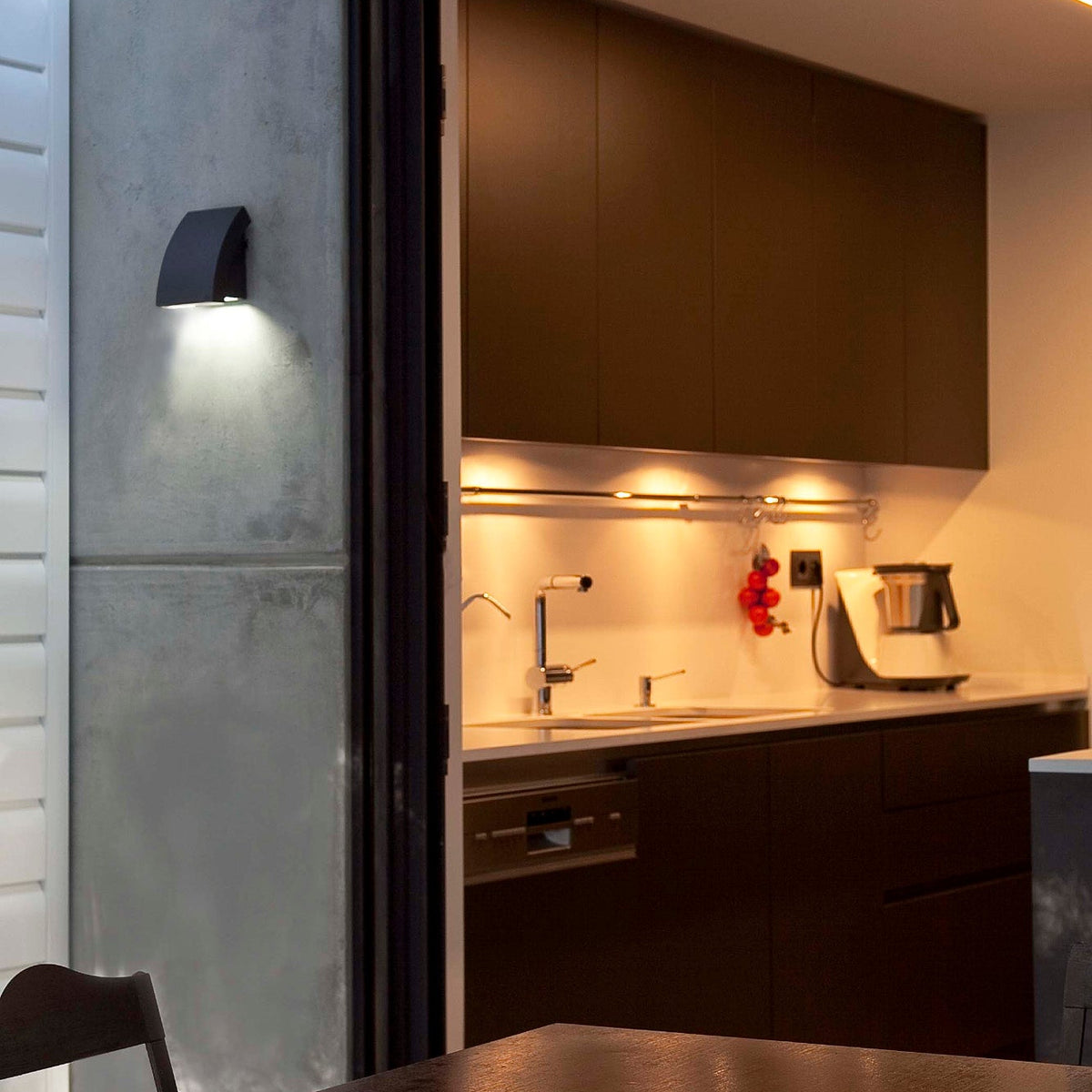 Modern kitchen with stainless steel appliances and a metallic wall.