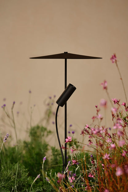 Black outdoor lamp with a wide shade in a garden setting