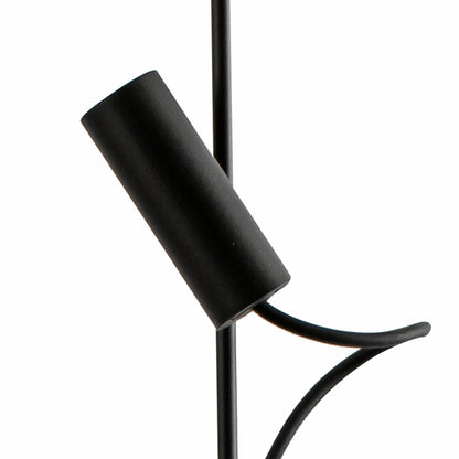 A close-up of a matte black modern floor lamp featuring a cylindrical shade, a central vertical pole, and a curved support bracket, shown against a solid white background.
