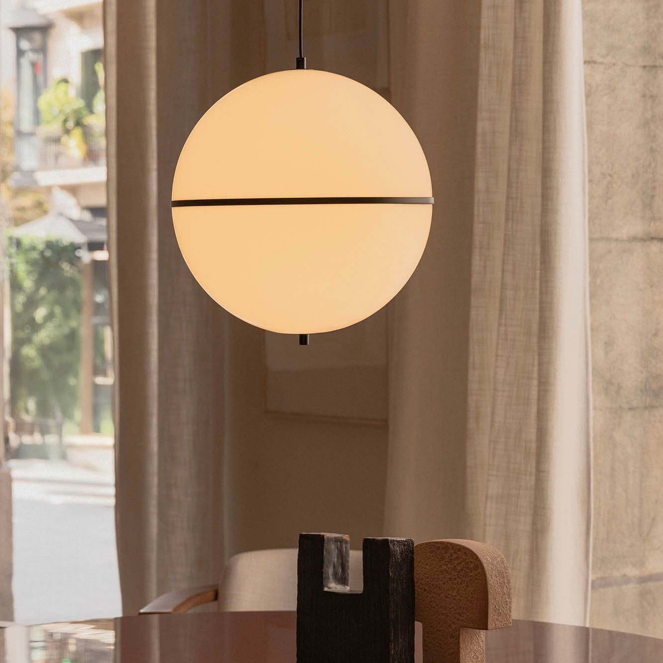 Round dining table with a pendant light in a modern interior setting