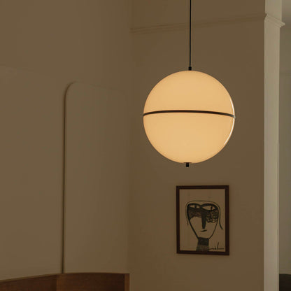 Bedroom with a spherical pendant light and framed artwork on the wall.