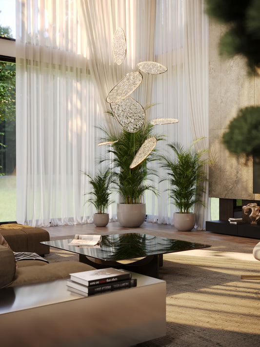 The Empire 110cm cascading LED chandelier suspended in a double-height modern living room with large sheer curtains and potted palms. Available to buy at the VXR Space store.