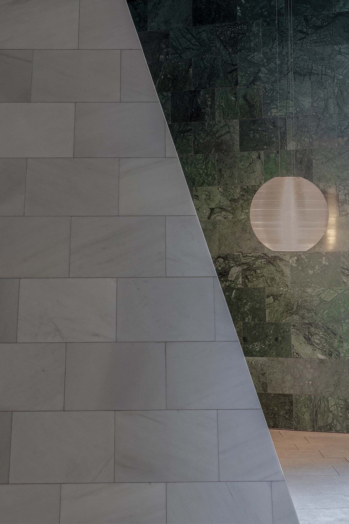 The Aire 450 translucent pendant light by Faro Barcelona suspended against green and white marble walls in a luxury interior. Available to buy at the VXR Space store.
