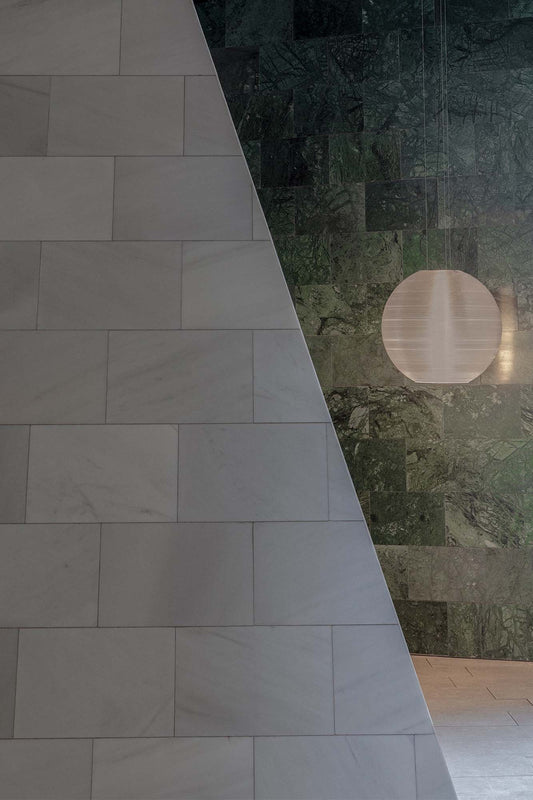 The Aire 450 translucent pendant light by Faro Barcelona suspended against green and white marble walls in a luxury interior. Available to buy at the VXR Space store.