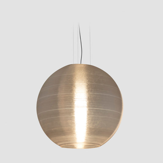 The AIRE 850 oversized pendant light by Faro Barcelona shown illuminated against a white background. The 3D-printed recycled PETG shade diffuses a warm, textured glow. Available to buy at the VXR Space store.