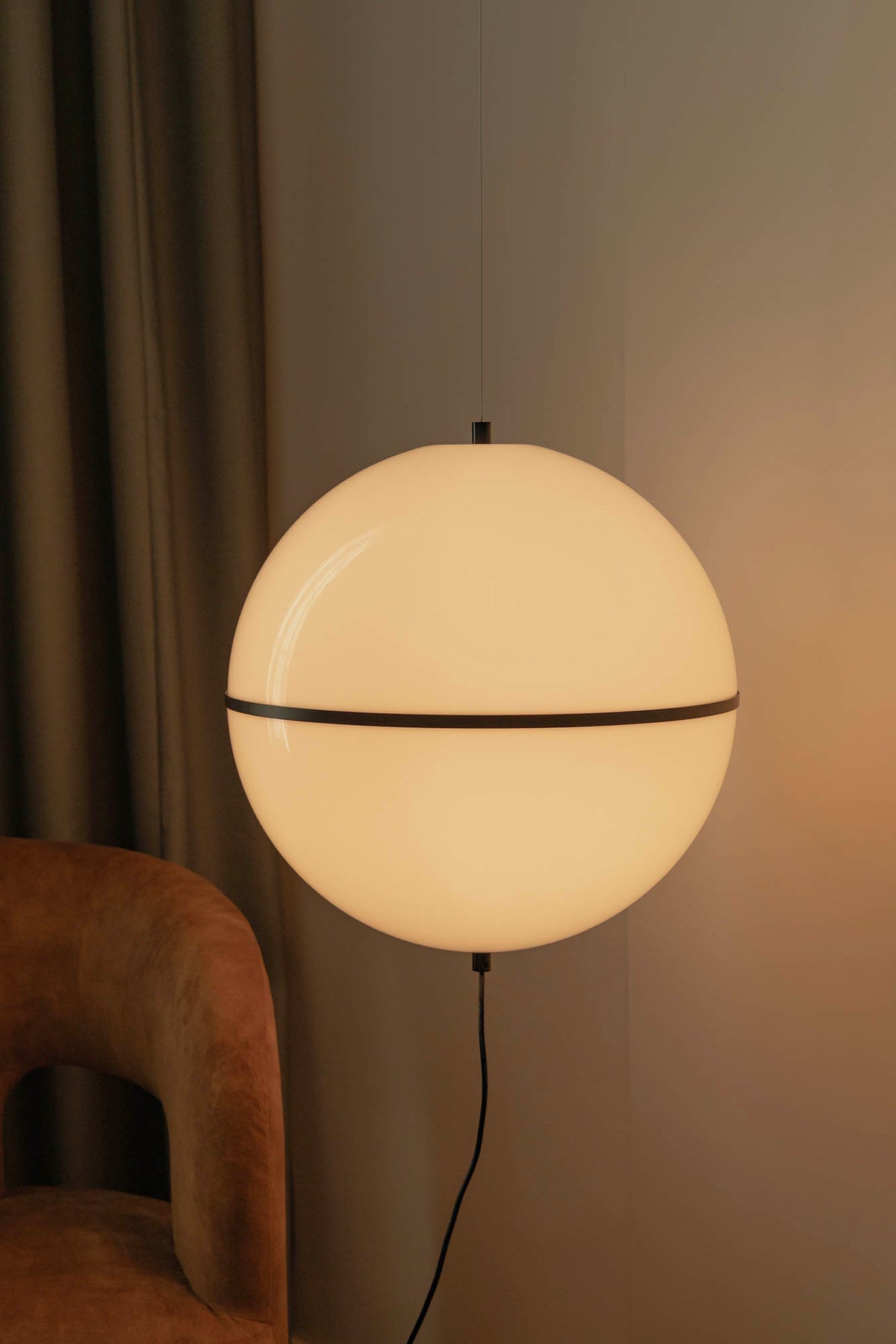 Close-up of the illuminated Dome M spherical pendant light by Faro Barcelona casting a warm diffused glow in an interior setting. Available to buy at the VXR Space store.