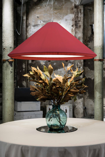 The Saigon-In 1300 garnet pendant light by Faro Barcelona suspended in a rustic-industrial interior above a table with a decorative vase. Showcases the fixture's monumental presence, available at the VXR Space store.