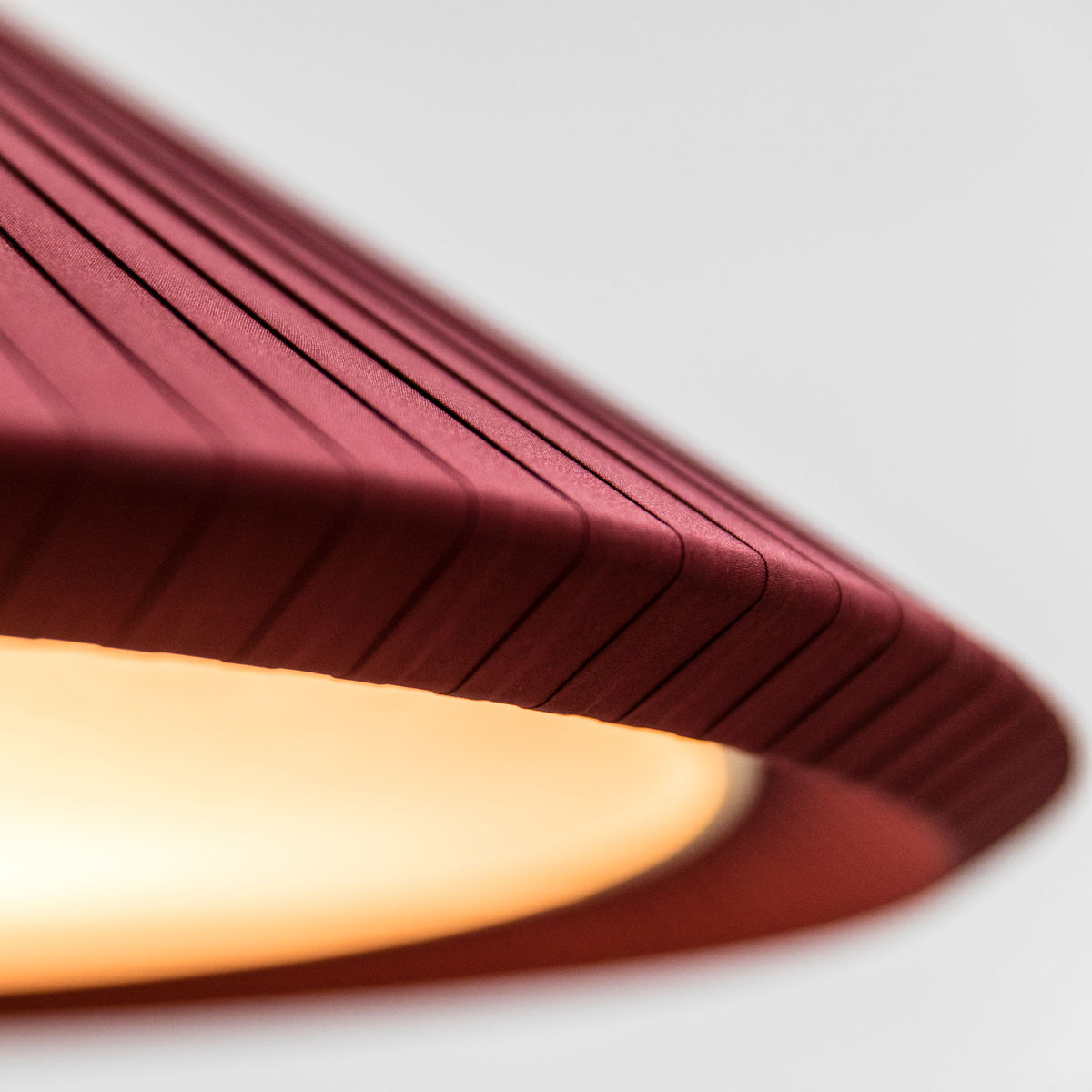 A close-up view of the Saigon-In 1300 garnet pendant light by Faro Barcelona, highlighting the intricate texture of the garnet red pleated textile ribbons. Available to buy at the VXR Space store.