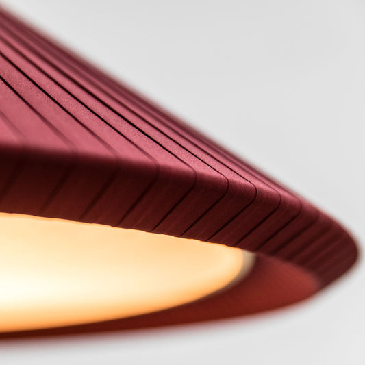 A close-up view of the Saigon-In 1300 garnet pendant light by Faro Barcelona, highlighting the intricate texture of the garnet red pleated textile ribbons. Available to buy at the VXR Space store.
