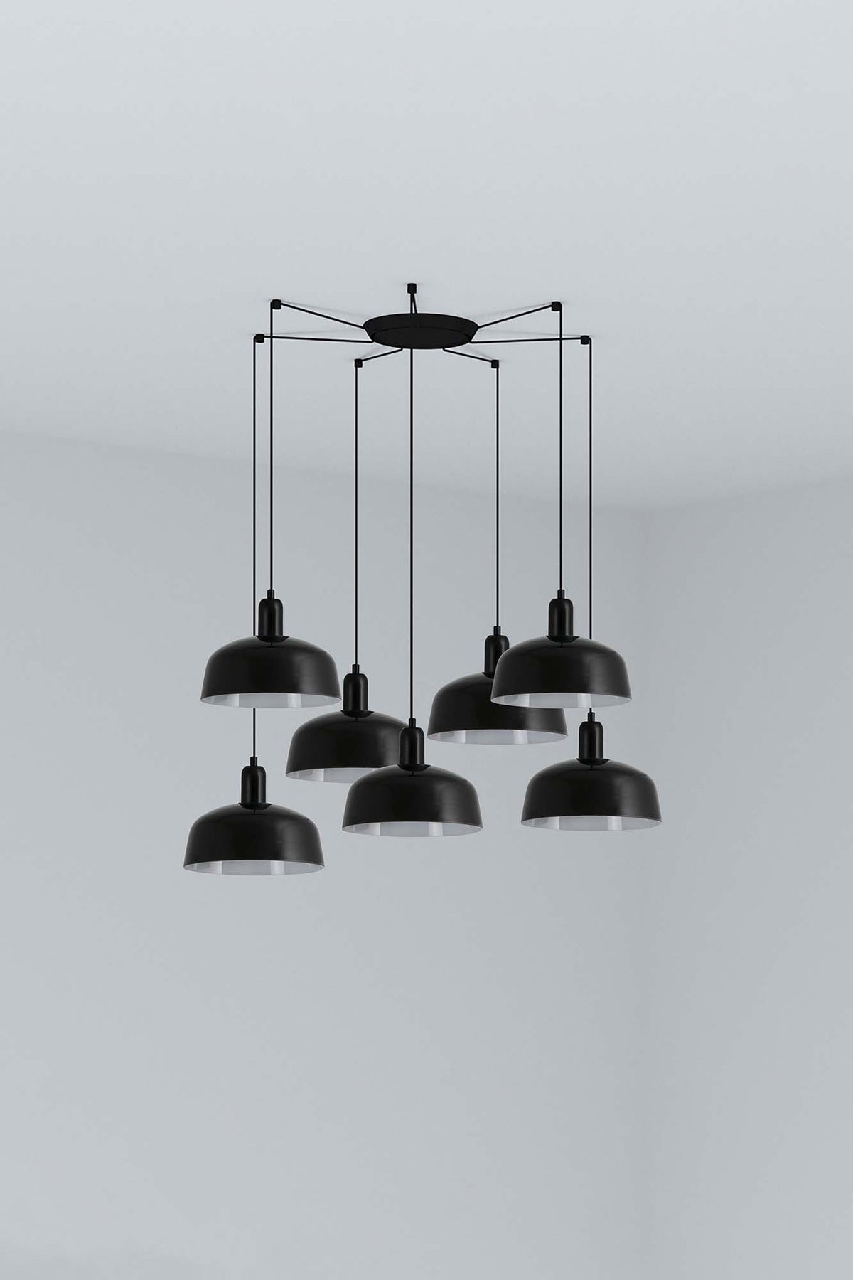 The Faro Barcelona Tatawin 7-light pendant lamp featuring a cluster of gloss black steel shades suspended from a minimalist black structure. Featured in the VXR Space lighting collection.