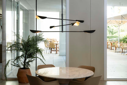 Modern dining area with a round table, chairs, and a stylish pendant light.