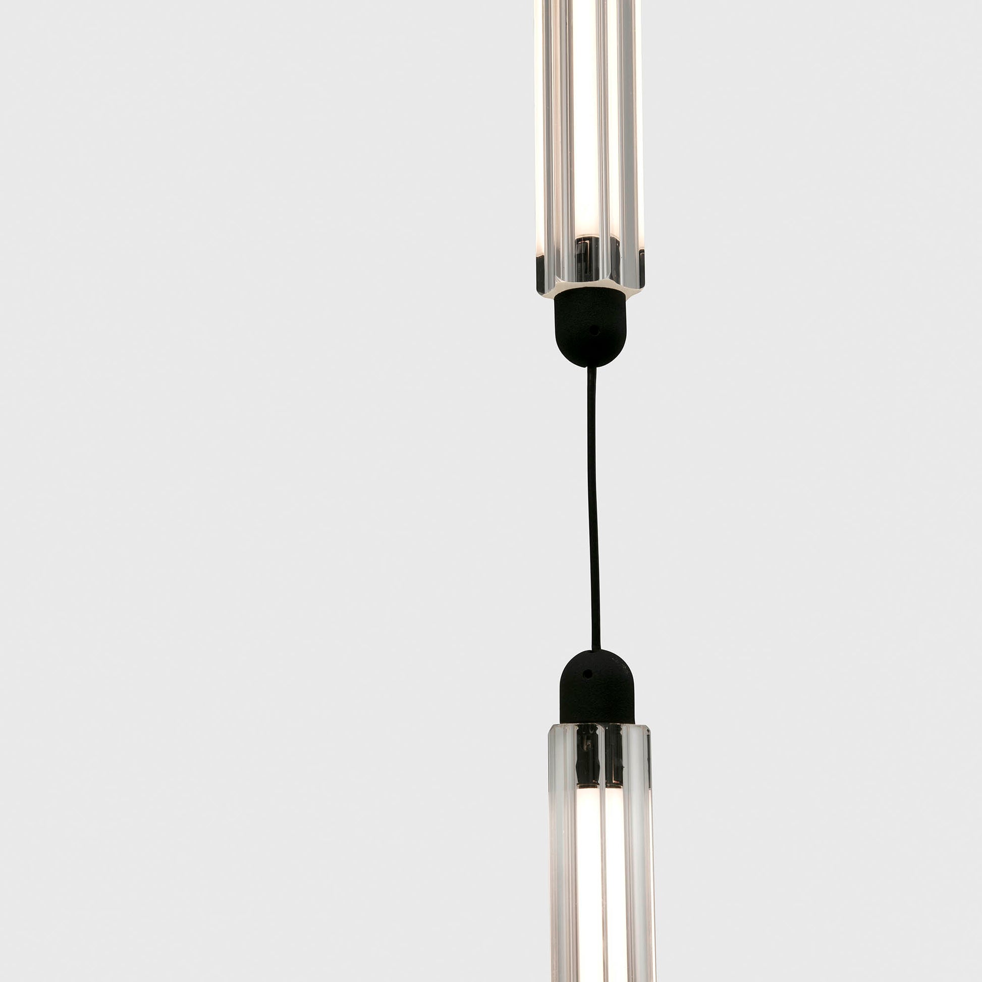 Modern pendant light with clear cylindrical design on a white background