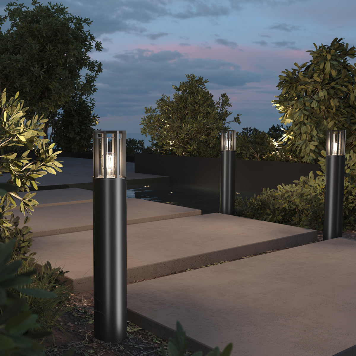 Outdoor garden pathway with cylindrical lamps illuminating the area.