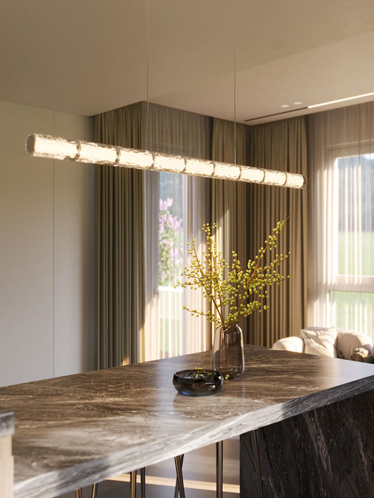 The Love 131.5cm linear LED pendant light suspended above a dark marble dining table in a modern interior with large windows and sheer curtains. Available to buy at the VXR Space store.