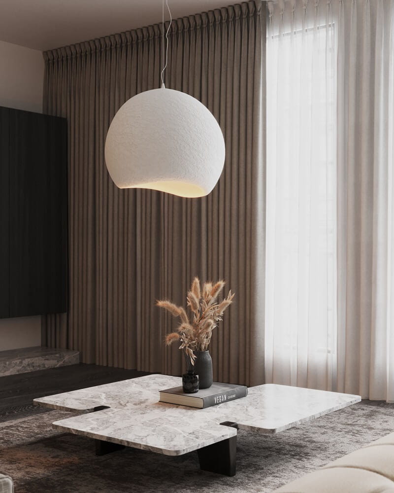 The MAXLight Pierre 48cm organic white resin pendant light suspended in a modern Nordic living room above a marble coffee table. Available to buy at the VXR Space store.