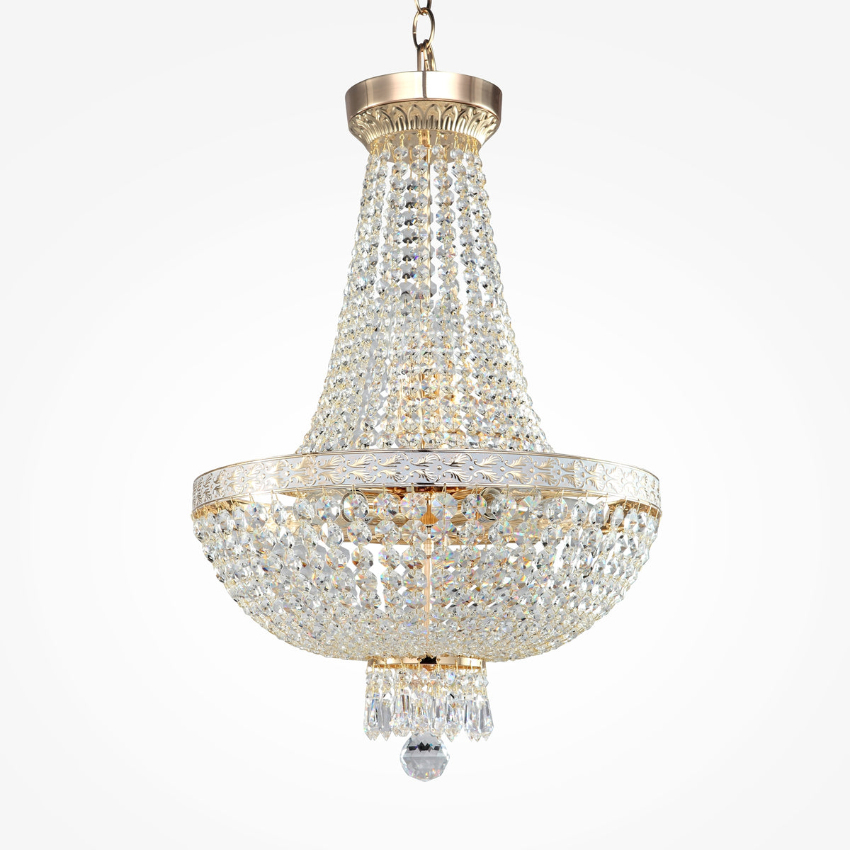 A luxurious empire-style crystal chandelier featuring a gleaming gold metal frame by Maytoni, hanging elegantly against a backdrop of tall white window drapes.