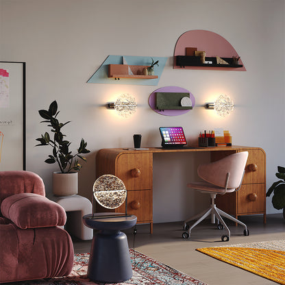 Two Maytoni Mangata textured acrylic wall sconces illuminating a vibrant, modern home office. The glowing round fixtures beautifully frame the workspace, complementing the colorful geometric wall shelves and the matching Mangata table lamp in the foreground.