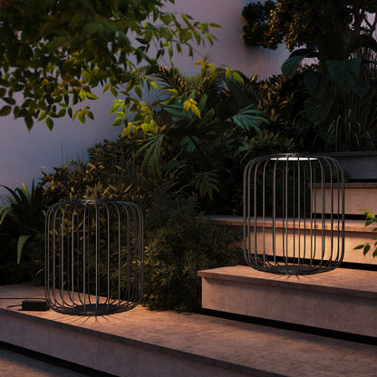 Decorative metal lanterns on a garden path with plants and steps in the background