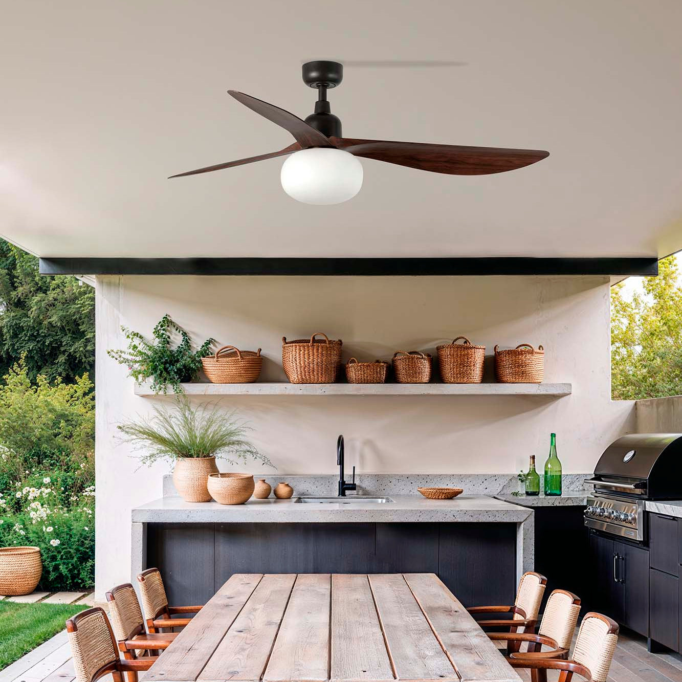 Outdoor kitchen with wooden dining table and ceiling fan lighting