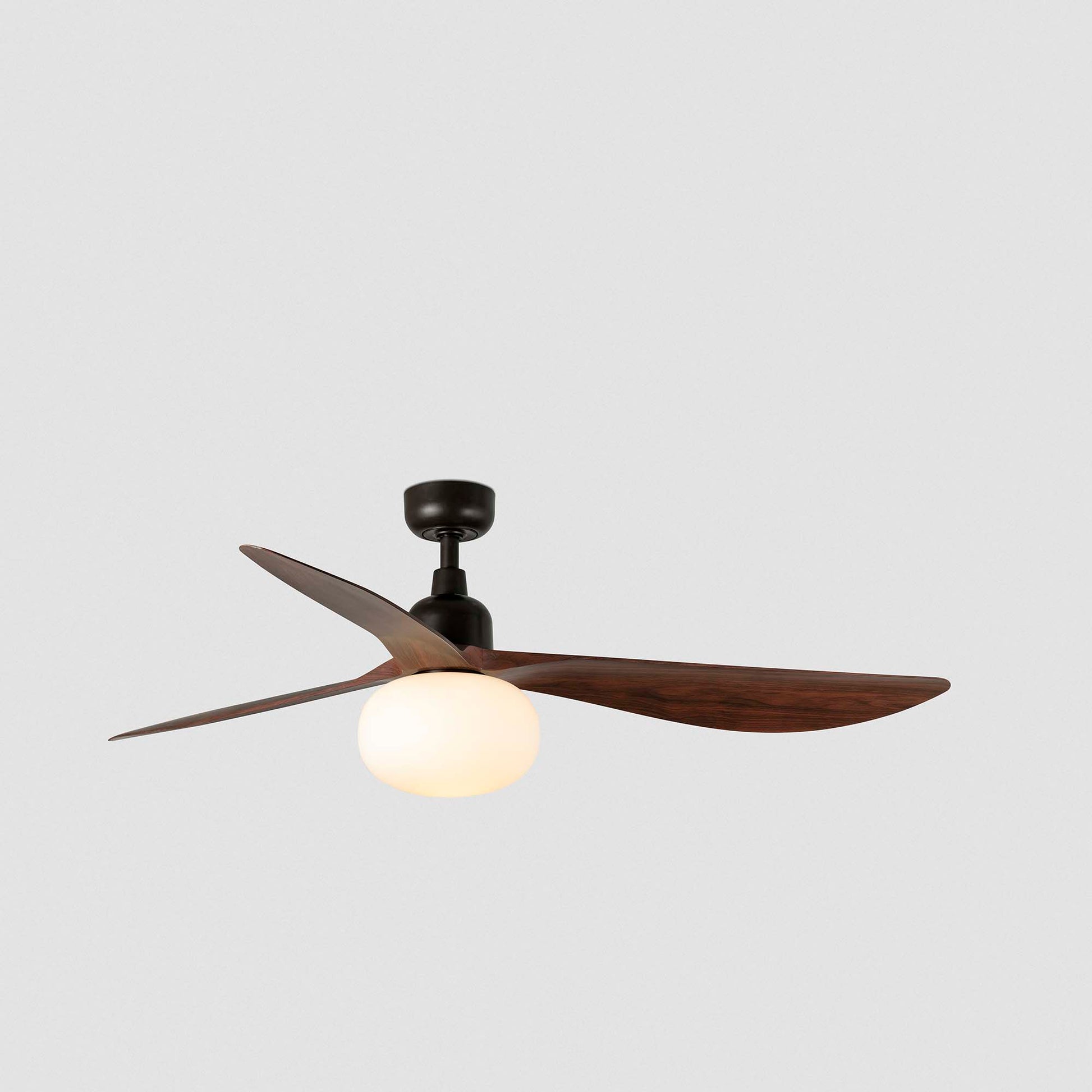 Ceiling fan with wooden blades and a light bulb on a gray background