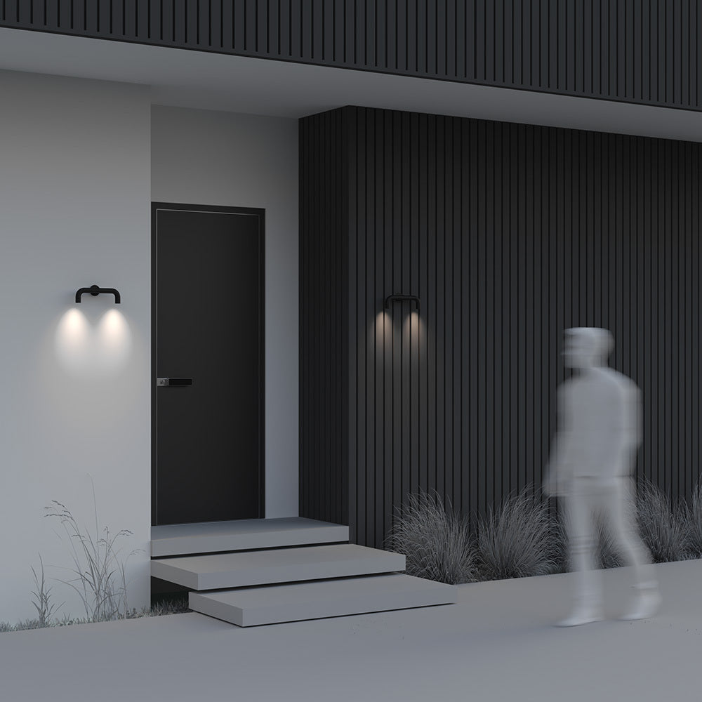 Modern house exterior with a person walking towards the door at night.