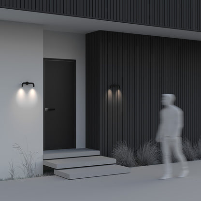 Modern house exterior with a person walking towards the door at night.