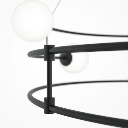Close-up of a modern black pendant light fixture with spherical glass shades on a white background.