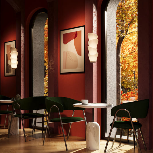 Modern cafe interior with red walls, green chairs, and a large window showing autumn foliage.